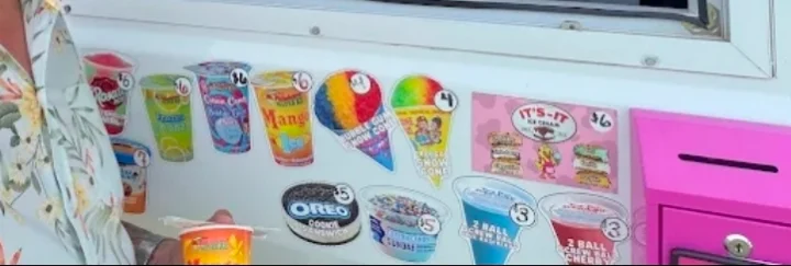 The menu stickers along the side of the truck: fruit cups, mango, cotton candy, Oreo cookie sandwich, bubble gum and rainbow snow cones, It's-It ice cream sandwiches and Screwballs