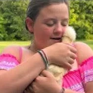 Sadie, the Dairy Duck Chief Ducky Officer, holding a duckling